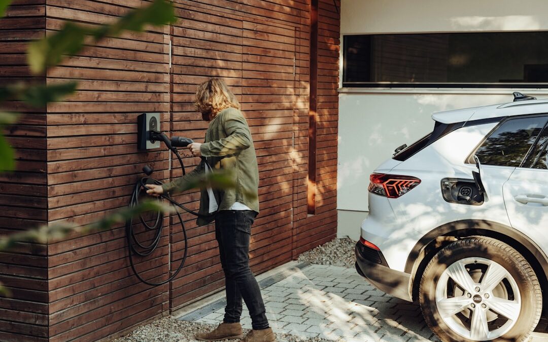 Certifierad elektriker som utför en säker installation av en Zaptec-laddbox på en tegelvägg i Malmö.